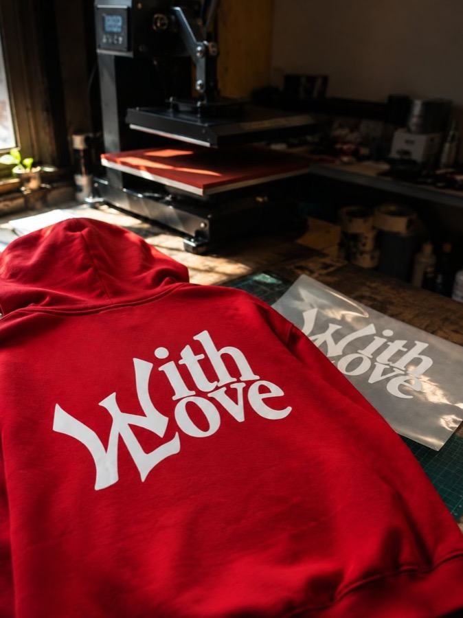 Sudadera roja con diseño DTF Textil recién planchada en el taller
